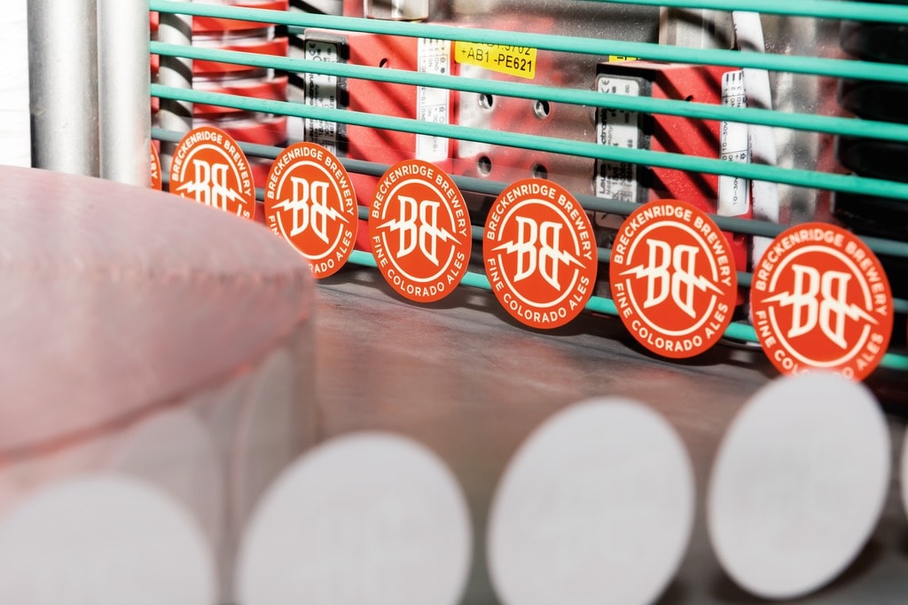 Eine Etikettiermaschine Autocol mit zwei Aggregaten stattet die Flaschen mit Selbstklebe-Etiketten aus.
